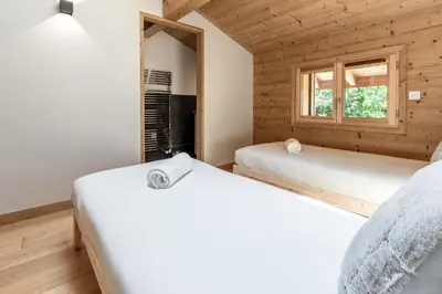 two beds in a room with a window at Les Trabets - Bellevue telecabine - Renove in Les Houches