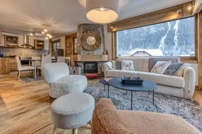 a living room with a couch and chairs and a table at Apt 8 pers hyper centre à Chamonix in Chamonix-Mont-Blanc