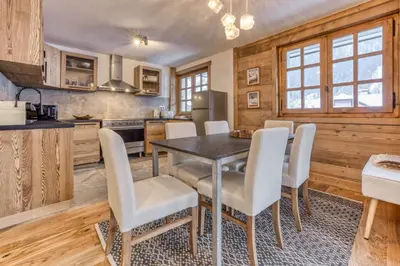 a kitchen and dining room with a table and chairs at Apt 8 pers hyper centre à Chamonix in Chamonix-Mont-Blanc
