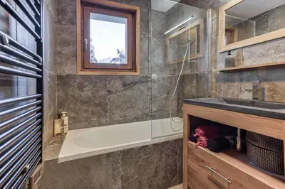 a bathroom with a tub and a sink at Apt 8 pers hyper centre à Chamonix in Chamonix-Mont-Blanc