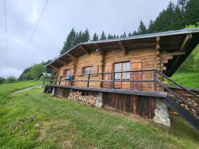 a log cabin on a hill with a grass field at Chalet d'alpage avec vue incroyable in Saint-Gervais-les-Bains