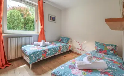 a bedroom with two beds and a child sitting on a pillow at Apartment Picasso in Chamonix-Mont-Blanc