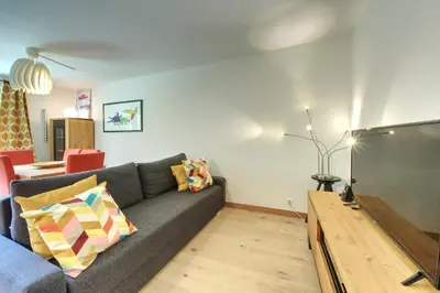a living room with a couch and a large screen tv at Apartment Picasso in Chamonix-Mont-Blanc