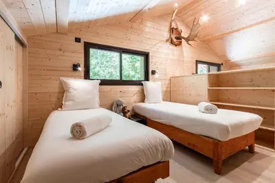 two beds in a room with wooden walls at Chalet Soljanel in Chamonix-Mont-Blanc