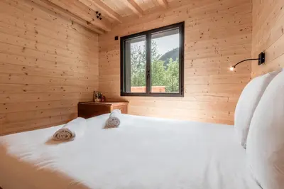 a bedroom in a log cabin with a bed and a window at Chalet Soljanel in Chamonix-Mont-Blanc