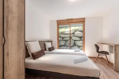 two beds in a room with a window at Alpage Mont Blanc in Combloux