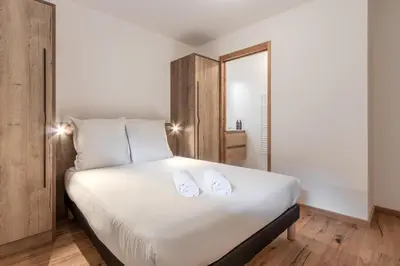 a bedroom with a white bed with two white towels at Alpage Mont Blanc in Combloux