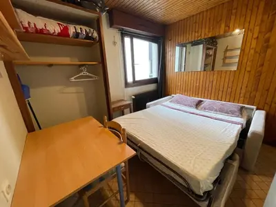 a small room with a bed and a table at Studio meublé bon emplacement in Chamonix-Mont-Blanc