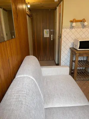 a couple of beds in a room with a door at Studio meublé bon emplacement in Chamonix-Mont-Blanc