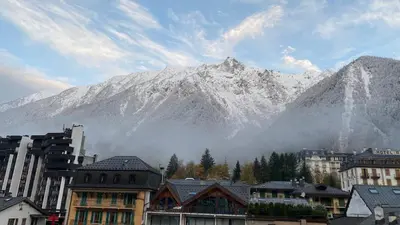 a mountain in the background of a city with buildings at Studio meublé bon emplacement in Chamonix-Mont-Blanc
