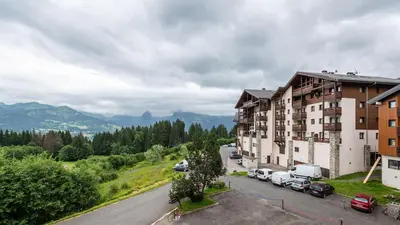 an apartment building with cars parked in a parking lot at P LES ESSERTS - 51 - Studio 4 pers in Morillon