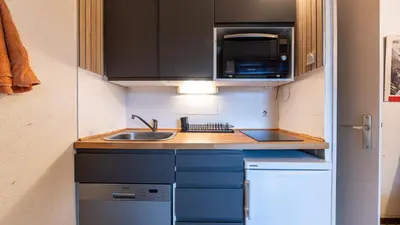 a small kitchen with a sink and a microwave at P LES ESSERTS - 51 - Studio 4 pers in Morillon
