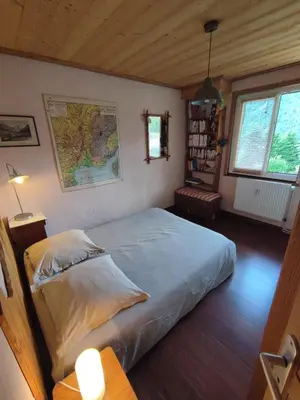 a bedroom with a bed and a map on the wall at Le Refuge des Trolls in Sixt