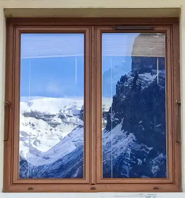 a window with a view of a snow covered mountain at Le Refuge des Trolls in Sixt