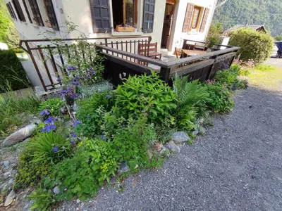 a garden with flowers in front of a house at Le Refuge des Trolls in Sixt