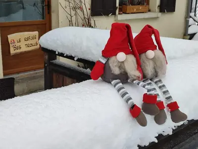 two stuffed animals wearing santa hats sitting on a bed at Le Refuge des Trolls in Sixt