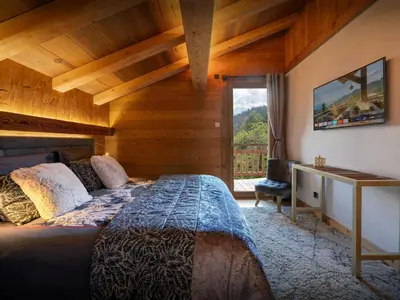 a bedroom with a large bed with a window at Chalet K1027 - OVO Network in Cordon