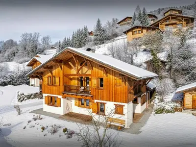 a wooden house in the snow with snow at Chalet Nahuel Huapi - OVO Network in Samoëns