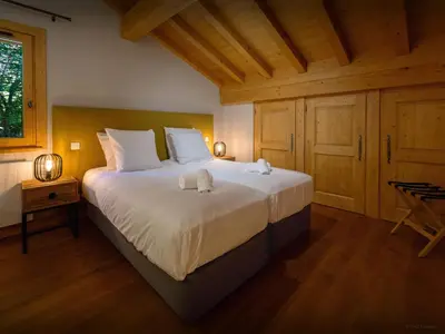 a bedroom with a large bed with two towels on it at Chalet Nahuel Huapi - OVO Network in Samoëns