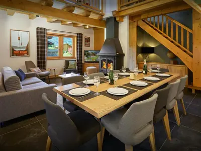 a dining room with a table and a fireplace at Chalet Nahuel Huapi - OVO Network in Samoëns