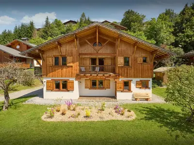 a large wooden house with a balcony in a yard at Chalet Nahuel Huapi - OVO Network in Samoëns