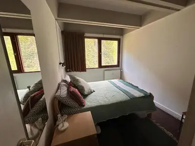 a small bedroom with a bed and two windows at Confortable appartement 3 pièces · Proche des pistes · WIFI · 6 pers - FR-1-425-225 in Arâches-la-Frasse