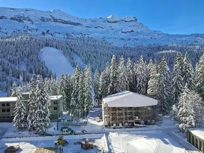 a snow covered mountain with trees and a building at Confortable appartement 3 pièces · Proche des pistes · WIFI · 6 pers - FR-1-425-225 in Arâches-la-Frasse