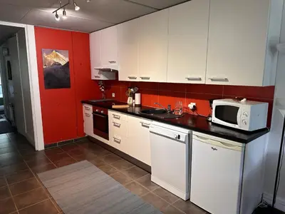 a kitchen with white cabinets and a microwave at Confortable appartement 3 pièces · Proche des pistes · WIFI · 6 pers - FR-1-425-225 in Arâches-la-Frasse