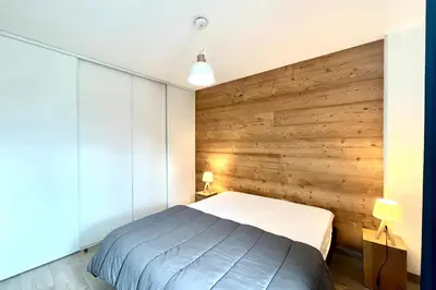 a bedroom with a wooden accent wall and a bed at Clair des Prés in Saint-Gervais-les-Bains