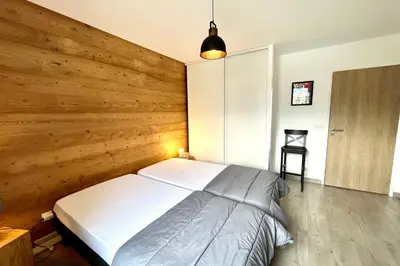 a bedroom with a wooden wall with a bed at Clair des Prés in Saint-Gervais-les-Bains