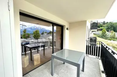 a glass table on the balcony of a house at Clair des Prés in Saint-Gervais-les-Bains