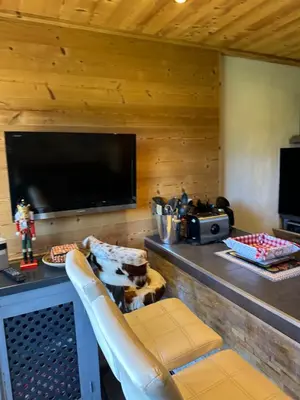 a living room with a television and a table with a chair at Scoot 4 étoiles in Demi-Quartier