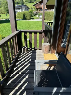 two chairs sitting on a wooden deck with a snow covered mountain at Scoot 4 étoiles in Demi-Quartier
