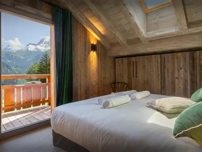 a bedroom with a large bed with a large window at Chalet Mussol - OVO Network in Saint-Gervais-les-Bains