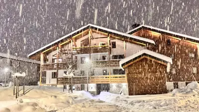 a house covered in snow in front at Flocons de Megève in Megève