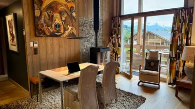 a dining room with a table with a laptop on it at Flocons de Megève in Megève