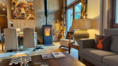 a living room with a couch and a fireplace at Flocons de Megève in Megève