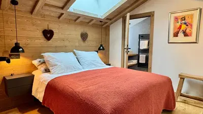 a bedroom with a large bed with a red blanket at Flocons de Megève in Megève