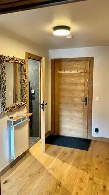 a bathroom with a wooden door and a mirror at Flocons de Megève in Megève