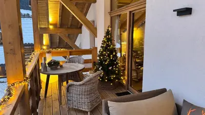 a balcony with a christmas tree and a table and chairs at Flocons de Megève in Megève