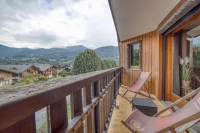 a balcony with chairs and a view of the mountains at Charmant appartement avec balcon et commodités modernes in Samoëns