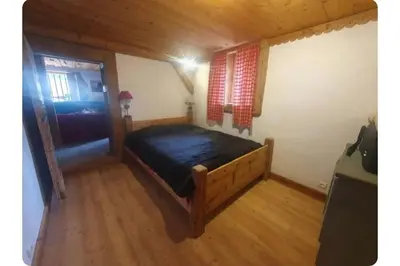 a bedroom with a large bed in a wooden room at Chalet Combe in Samoëns