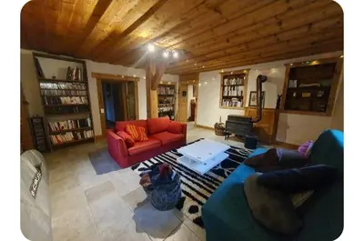 a living room with a red couch and a table at Chalet Combe in Samoëns