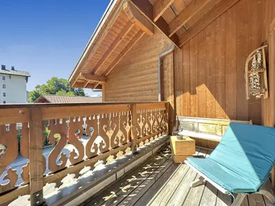 a wooden balcony with a blue bench on it at CRIS112 - Duplex 8 personnes centre village in Les Carroz d'Araches