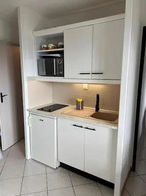 a kitchen with white cabinets and a sink at Appartement centre Saint Gervais-Vue imprenable in Saint-Gervais-les-Bains