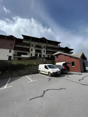 a white car parked in a parking lot in front of a building at Appartement centre Saint Gervais-Vue imprenable in Saint-Gervais-les-Bains