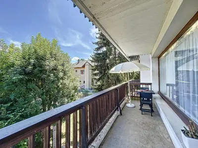 a balcony with an umbrella and a table and chair at Appartement 3 pièces avec balcon et parking à Combloux - FR-1-560-146 in Combloux