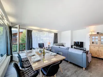 a living room with a table and a blue couch at Appartement 3 pièces avec balcon et parking à Combloux - FR-1-560-146 in Combloux