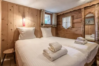 two twin beds in a room with wooden walls at Le Gite - Le Mont d'Arbois - 5 pax in Saint-Gervais-les-Bains