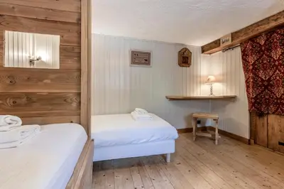 two twin beds in a room with wooden walls at Le Gite - Le Mont d'Arbois - 5 pax in Saint-Gervais-les-Bains